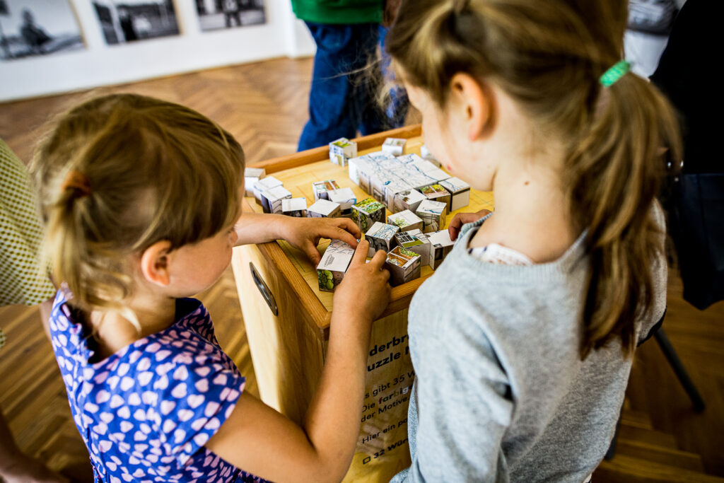 Kinder spielen mit einem Würfelspiel im Oderbruchmuseum