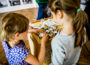 Kinder spielen mit einem Würfelspiel im Oderbruchmuseum