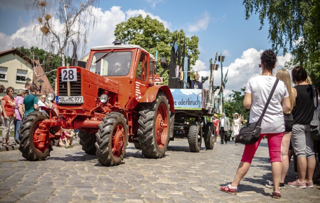 roter Traktor auf der Parade zum Oderbruchtag in Neutrebbin und Publikum